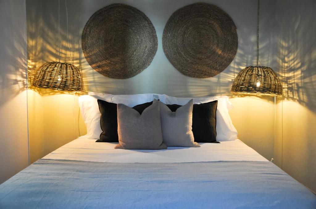 um quarto com uma cama com duas cestas penduradas em Casa Salinas, Elegant Flat w patio in Taviras Historical Centre em Tavira