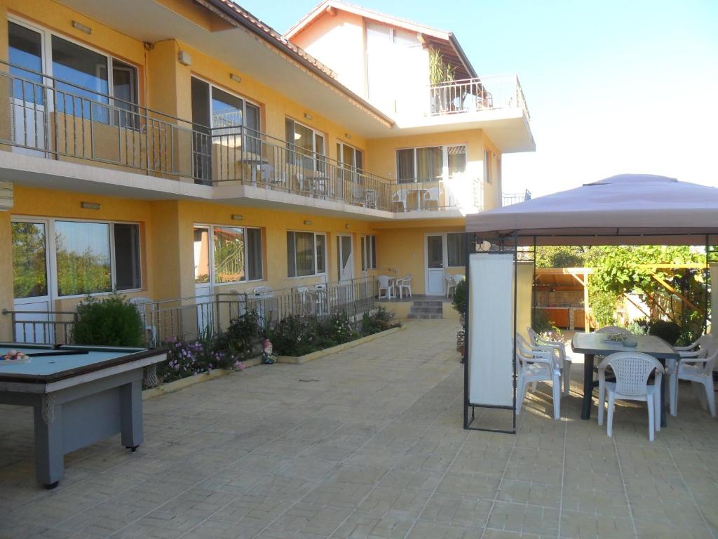 an outdoor patio with a pool table and an umbrella at Eleonor Guest House in Byala