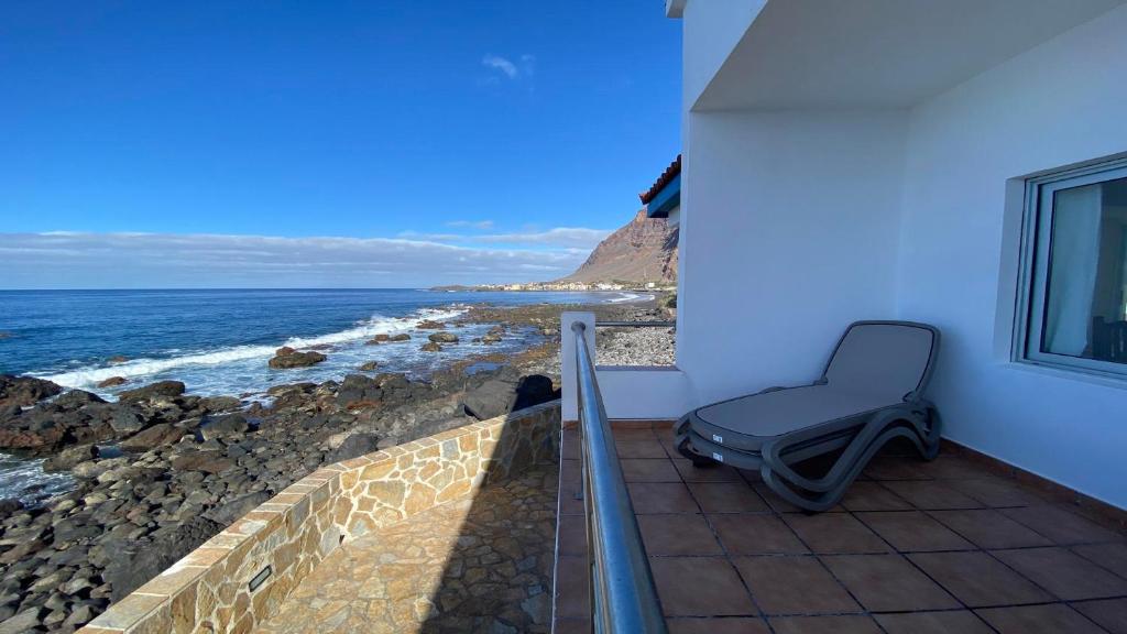 a chair sitting on a balcony looking at the ocean at Casa Camilo I in Valle Gran Rey