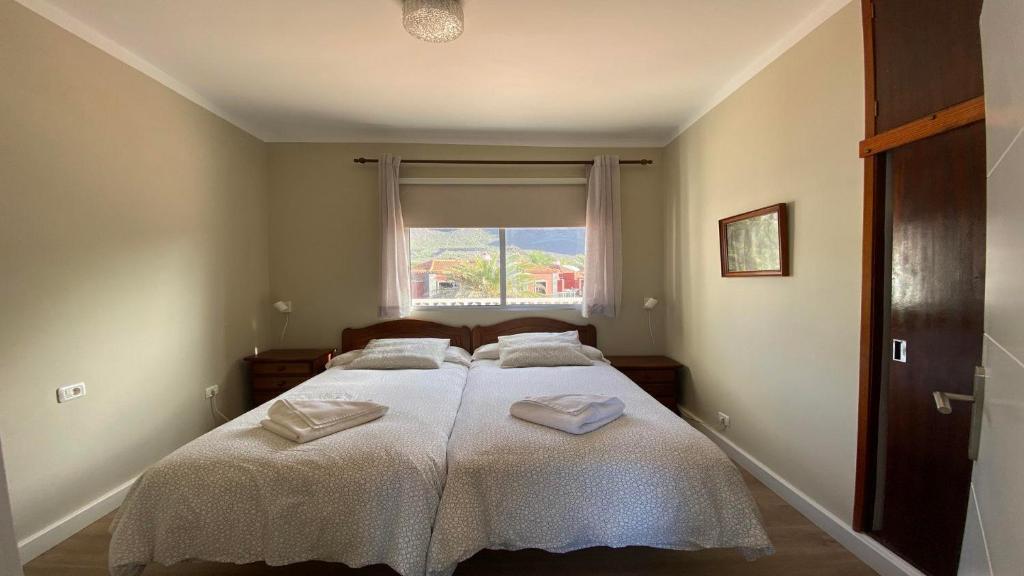 a bedroom with two beds with white sheets and a window at Casa Camilo I in Valle Gran Rey
