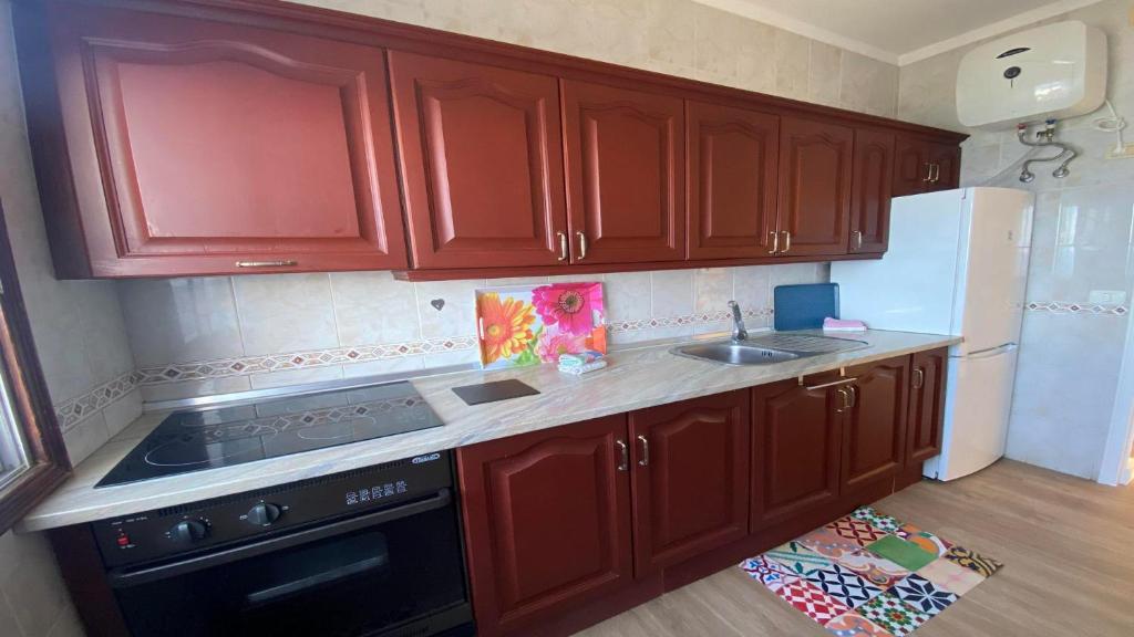 a kitchen with wooden cabinets and a stove and refrigerator at Casa Camilo I in Valle Gran Rey