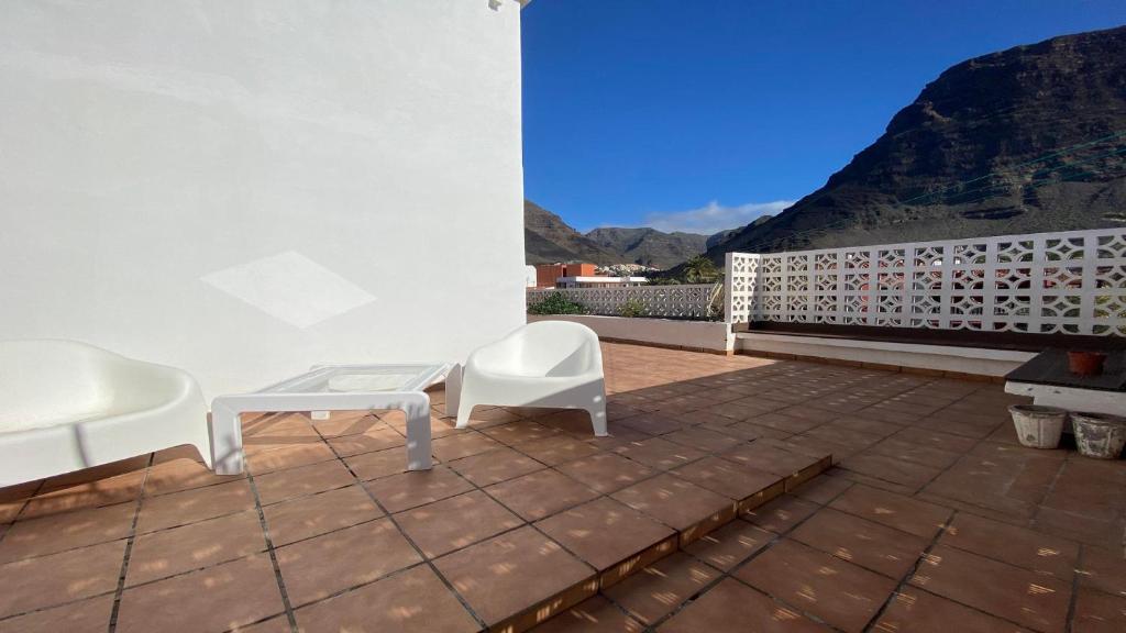 a patio with two white chairs and a table at Casa Camilo I in Valle Gran Rey