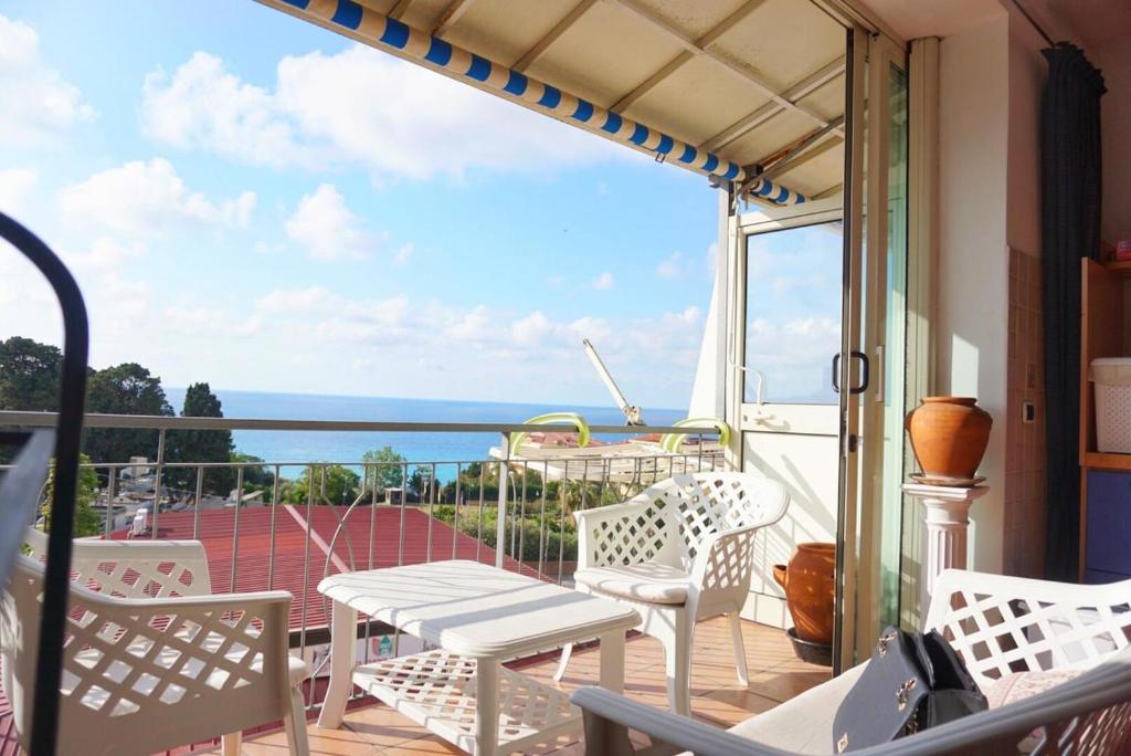 einen Balkon mit Stühlen, einem Tisch und Meerblick in der Unterkunft Stars Home in Tropea