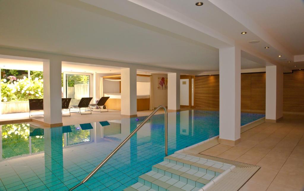 a swimming pool in a hotel with a room at Gartenhotel Feldeck in Lauchringen