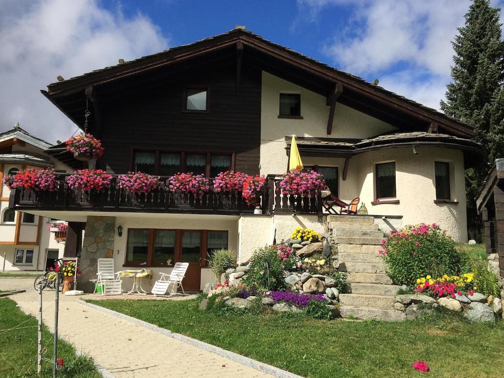 a house with a balcony with flowers on it at Apartment Chalet Sunstar- grosse Wohnung by Interhome in Saas-Fee