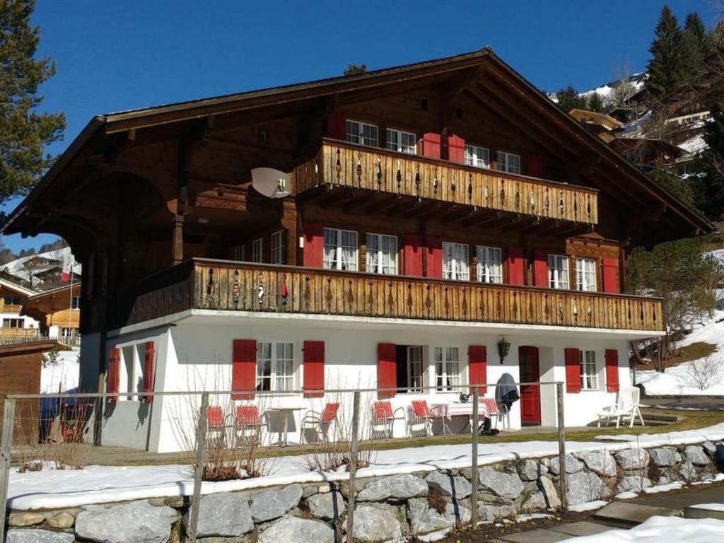 a large wooden building with red and white at Apartment Bärnermutz # 1 by Interhome in Lenk