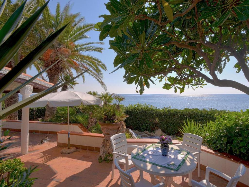 フロリーディアにあるVilla Villa Tanah-Lot by Interhomeの海を望むパティオ(テーブル、椅子付)