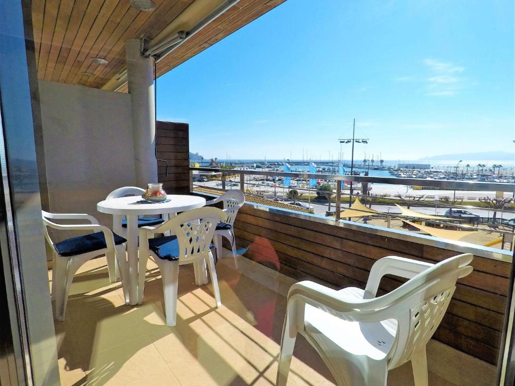 埃斯塔蒂特的住宿－Apartment La Platja by Interhome，阳台配有桌椅,享有海港的景致。
