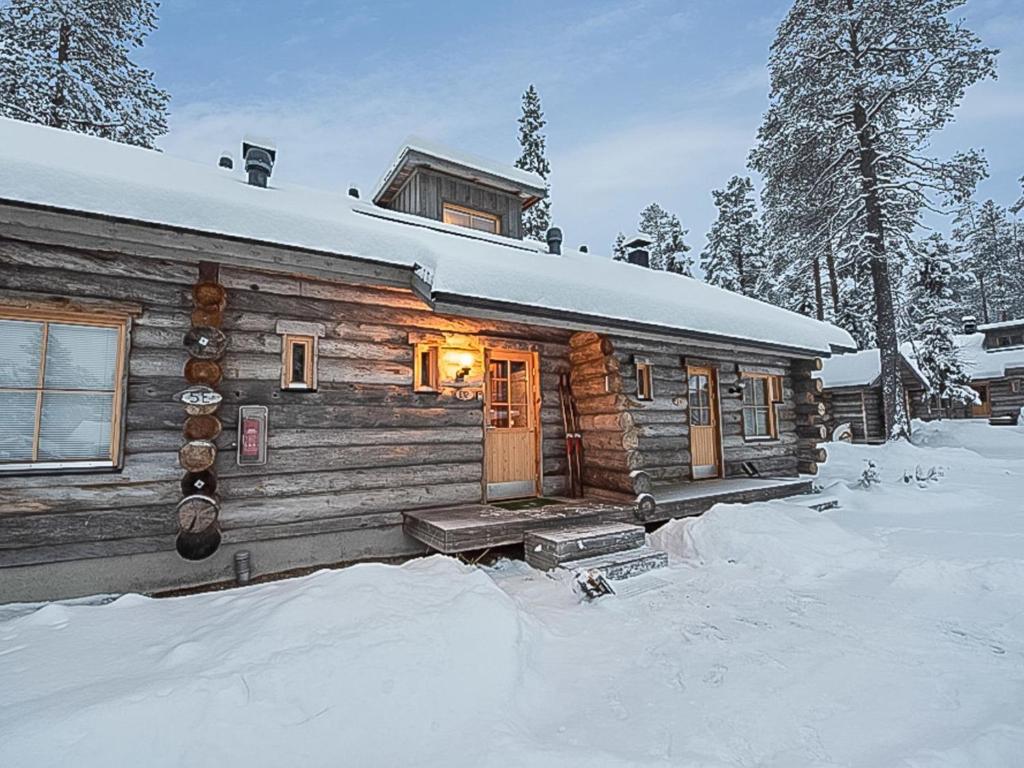 eine Blockhütte im Schnee mit Licht in der Unterkunft Holiday Home Ylläsniesta 5 e 12 by Interhome in Äkäslompolo