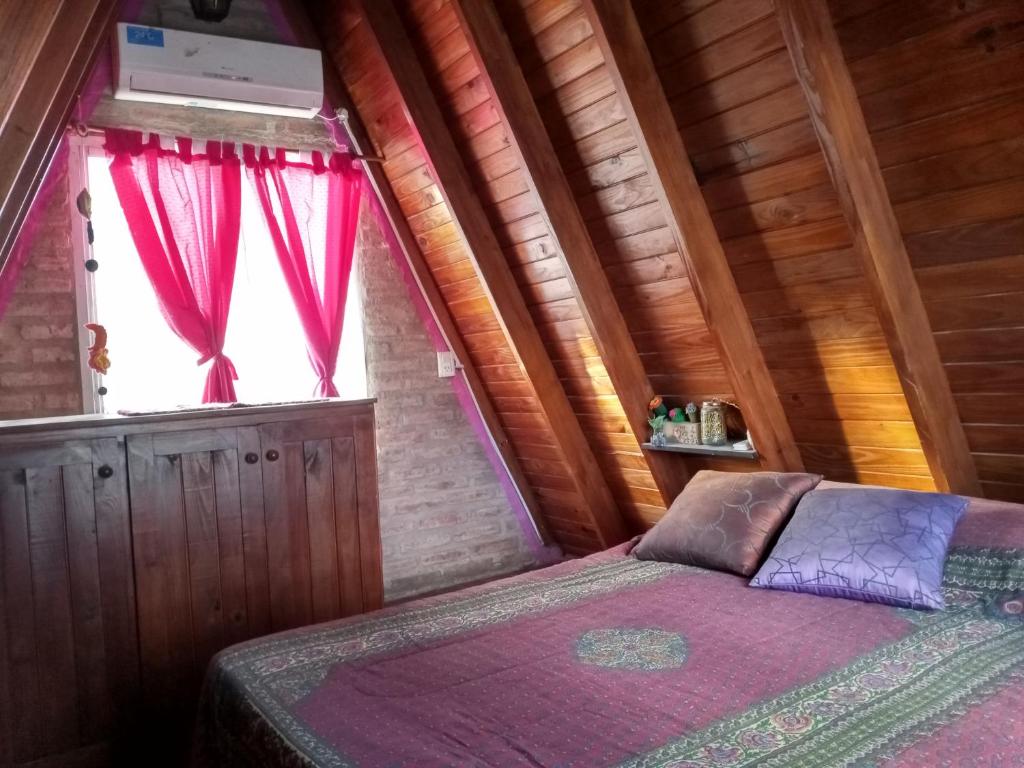 a bedroom with a bed and a window at Cabañas Terra Natura in Bialet Massé