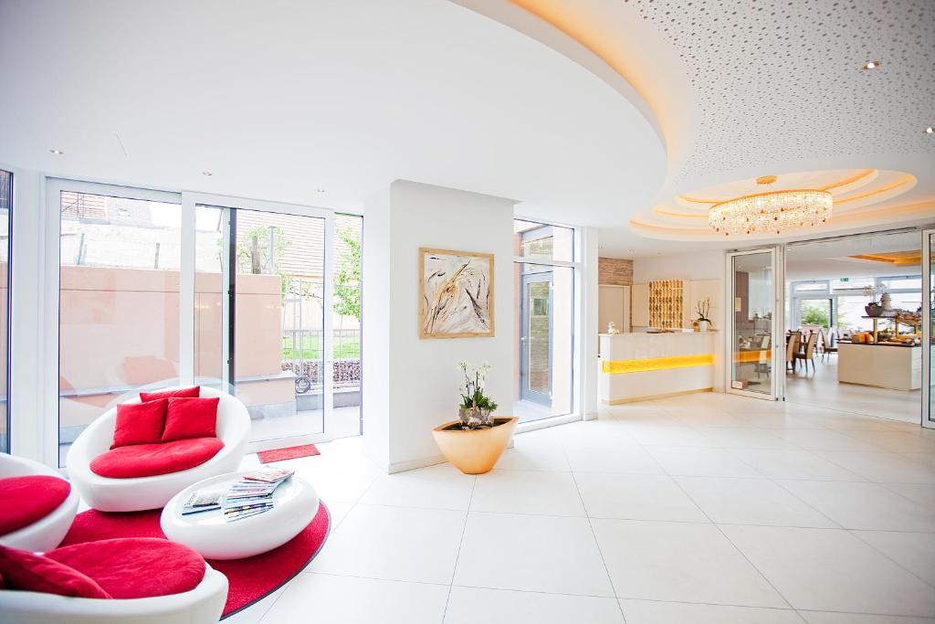 ein Wohnzimmer mit roten Kissen auf einem roten Teppich in der Unterkunft Hotel Krone OHG in Gerlingen