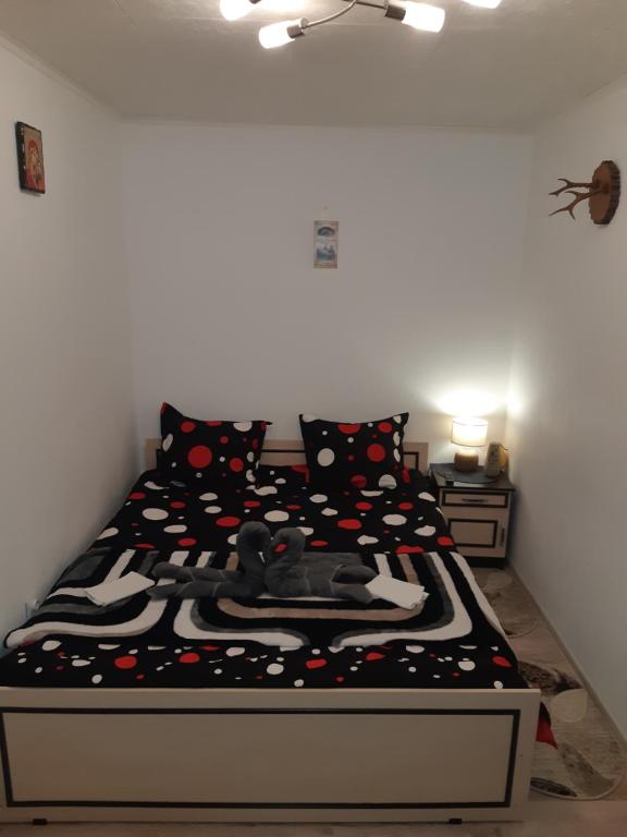 Un dormitorio con una cama con almohadas negras y rojas en Florin Apartament, en Sighişoara