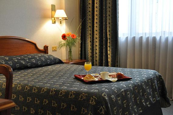 Una habitación de hotel con una cama con una bandeja con una bebida. en ATLAS TOWER HOTEL en Buenos Aires