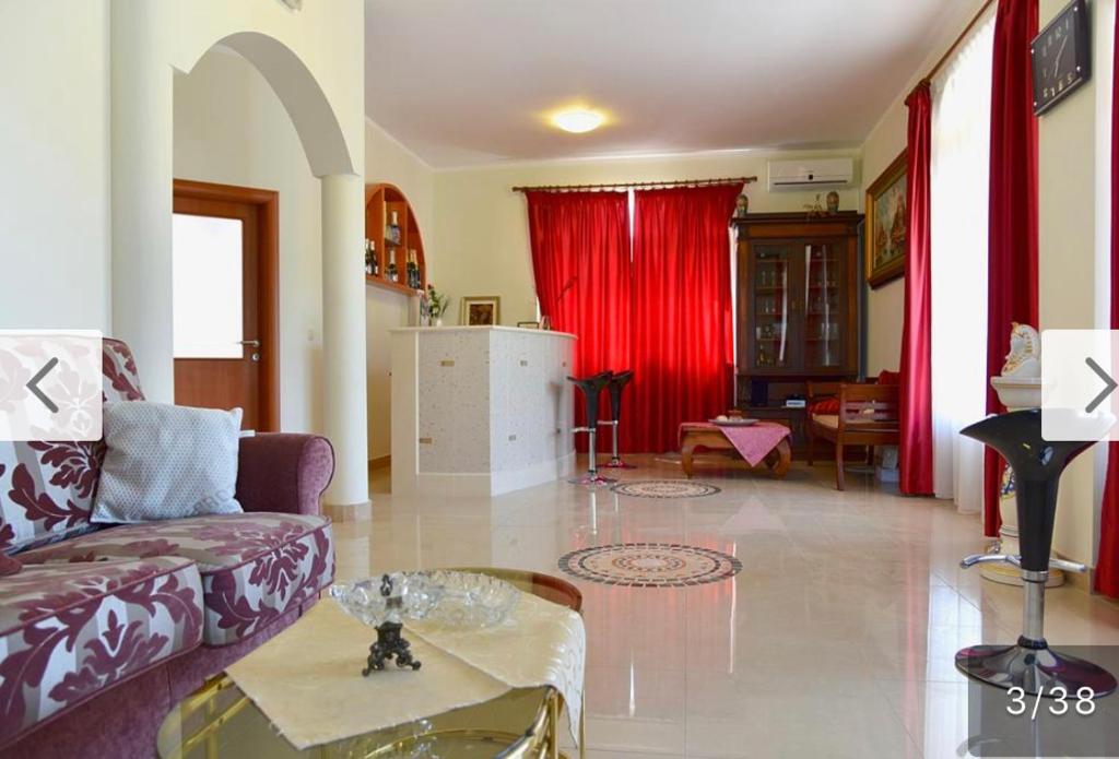 a living room with a couch and a red curtain at Villa D in Trogir