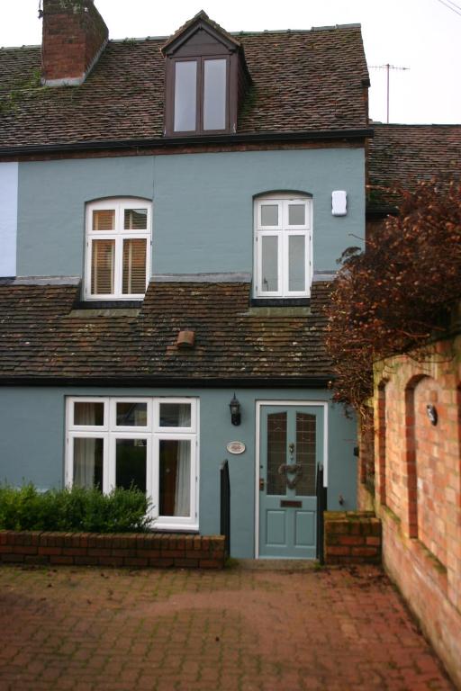 una casa azul con una puerta y ventanas azules en Corner Cottage en Bewdley