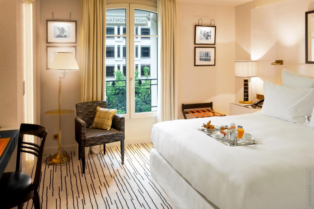 a hotel room with a bed with a tray of fruit on it at Hotel Montaigne in Paris