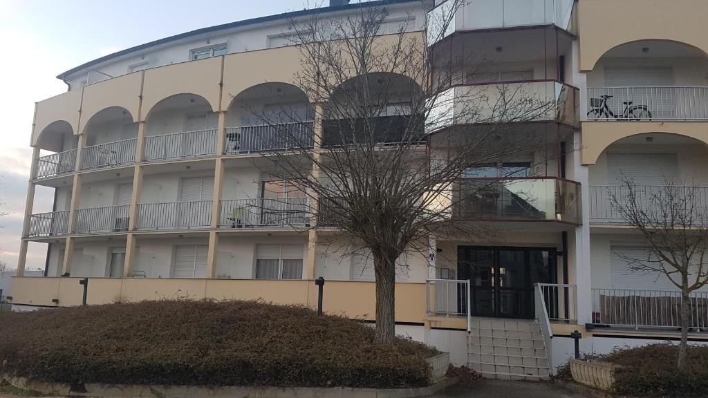 un bâtiment avec un arbre en face dans l'établissement Studio Oxford, à Chevigny-Saint-Sauveur