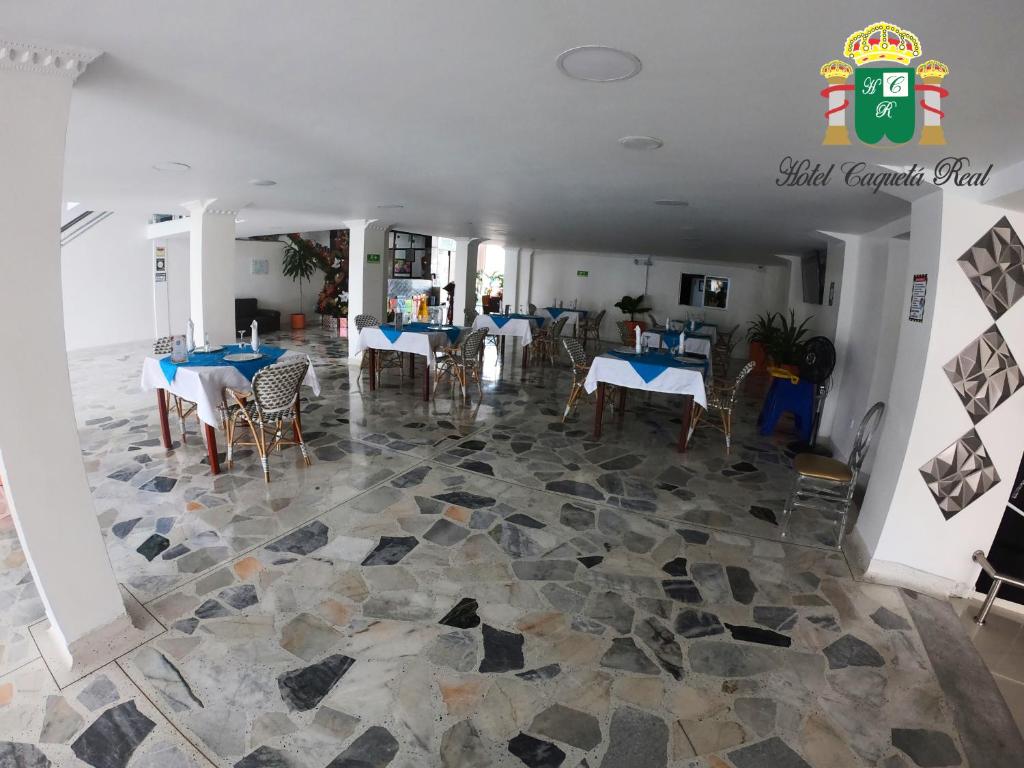 un restaurante con mesas y sillas en un suelo de piedra en Hotel Caquetá Real HSC, en Florencia