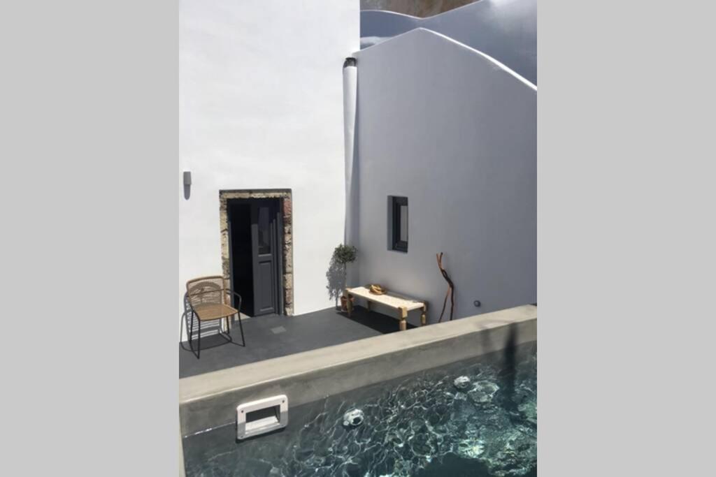 a house with a pool in the middle of it at Santorini Folia Cave house, 4 pers, view, jacuzzi in Pirgos