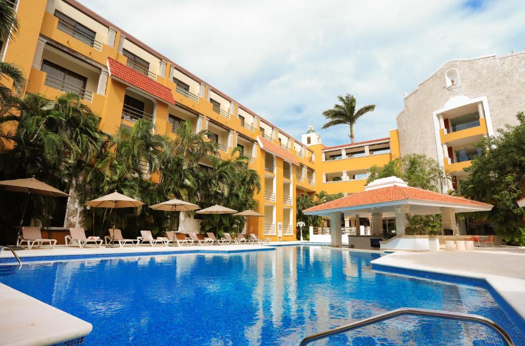 une piscine en face d'un hôtel dans l'établissement Adhara Hacienda Cancun, à Cancún