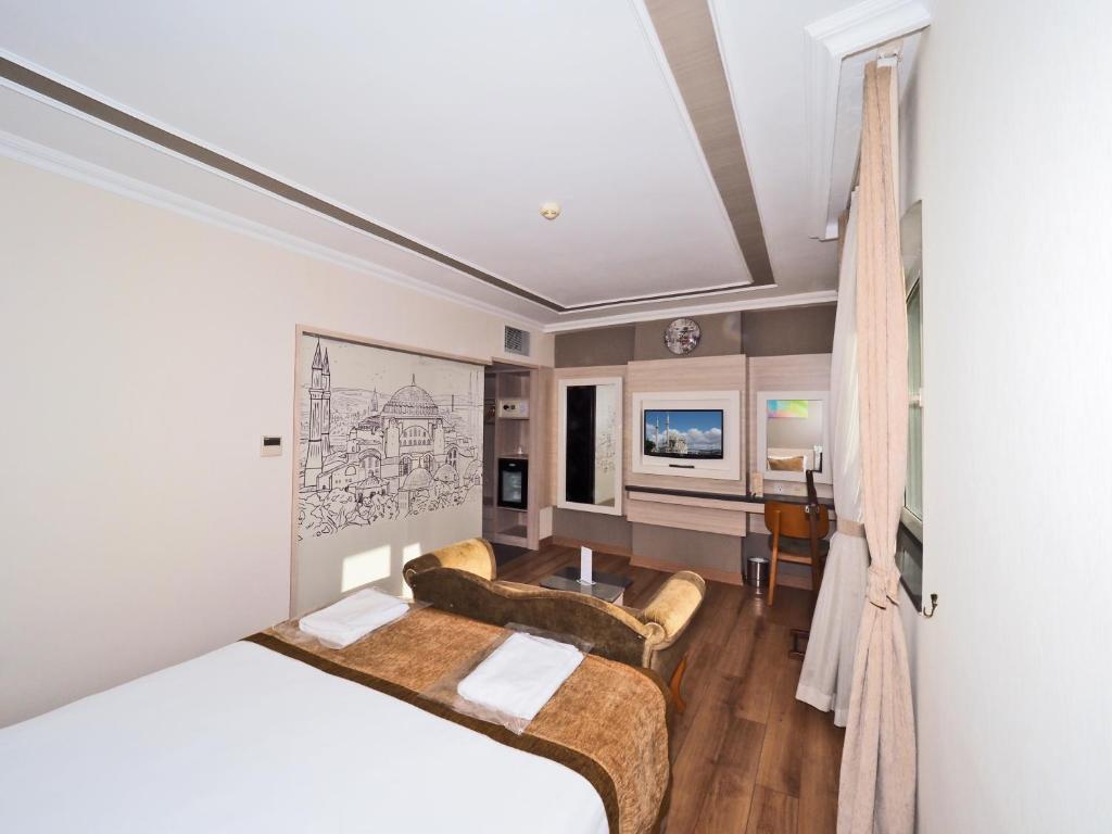 イスタンブールにあるHotel Bulvar Palasのベッドとデスクが備わるホテルルームです。