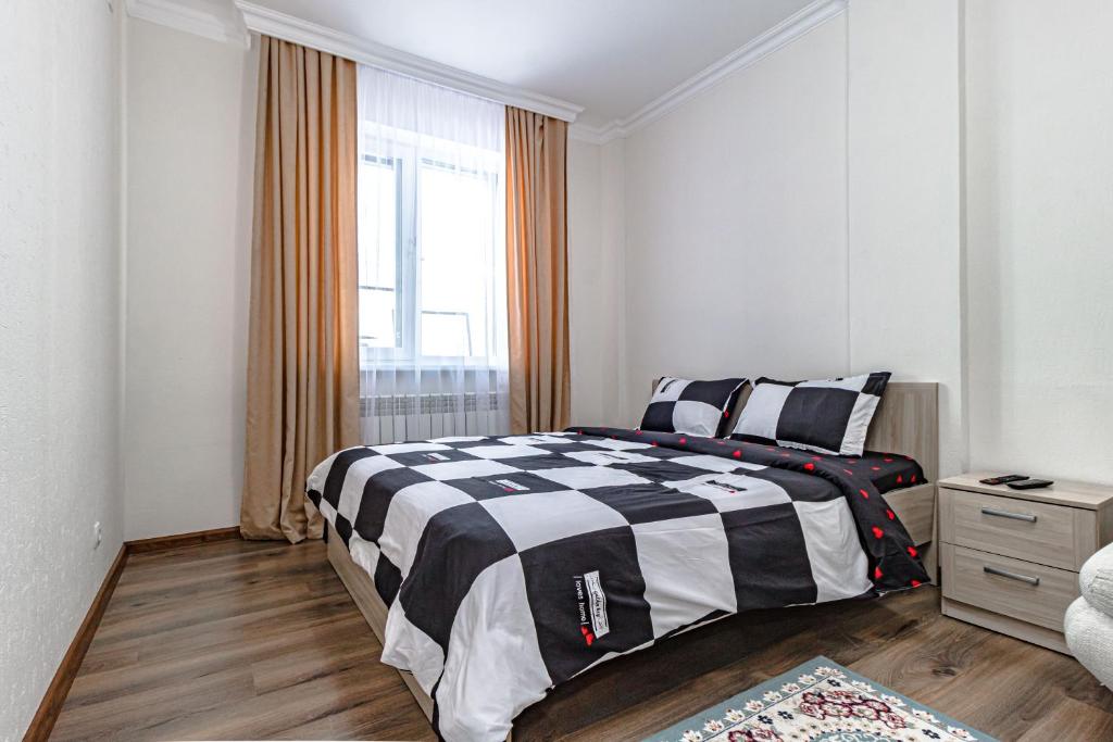 a bedroom with a black and white bed and a window at BI CITY SEUOL 116 in Astana