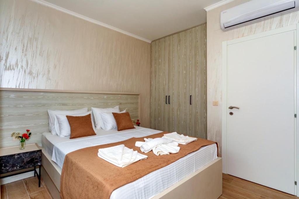 a bedroom with a bed with towels on it at Luxury Apartments Queen in Petrovac na Moru