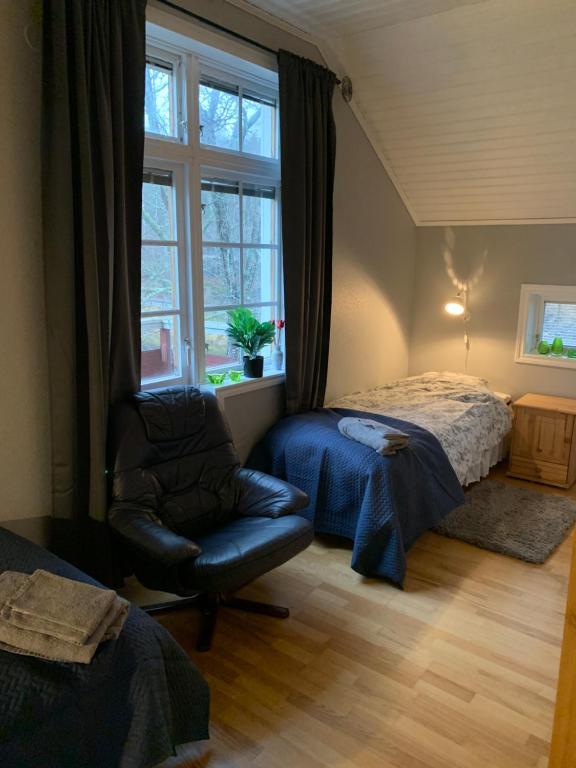 1 dormitorio con 1 cama, 1 silla y 1 ventana en Sea Side Cabin en Borlänge