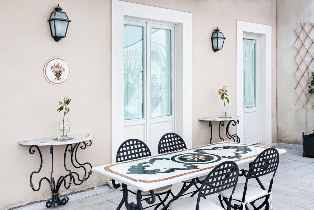 Dimora Fortebraccio في لاكويلا: غرفة طعام مع طاولة وكراسي