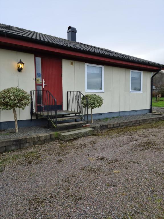 Biały i czerwony dom z czerwonymi drzwiami w obiekcie Östra Karup Båstad w mieście Östra Karup
