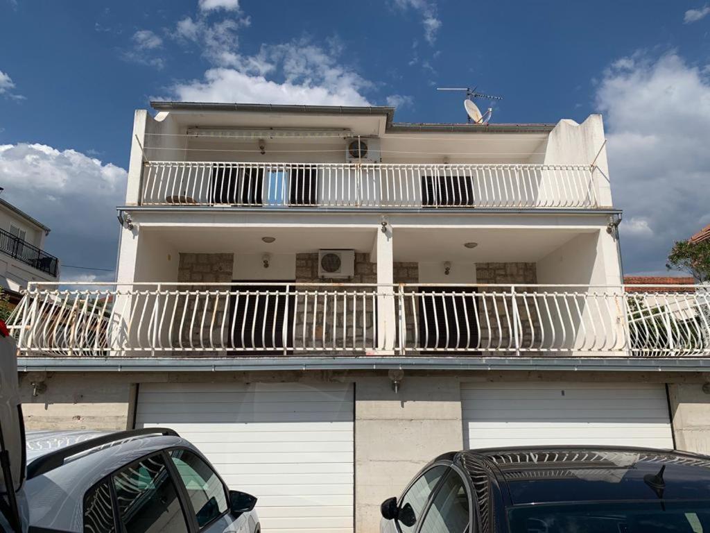 Cette maison blanche dispose d'un balcon. dans l'établissement Apartmani Antonio 1, à Brodarica