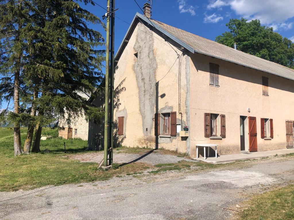 un viejo edificio blanco con un poste delante en Maison campagne au col du festre, en Le Dévoluy