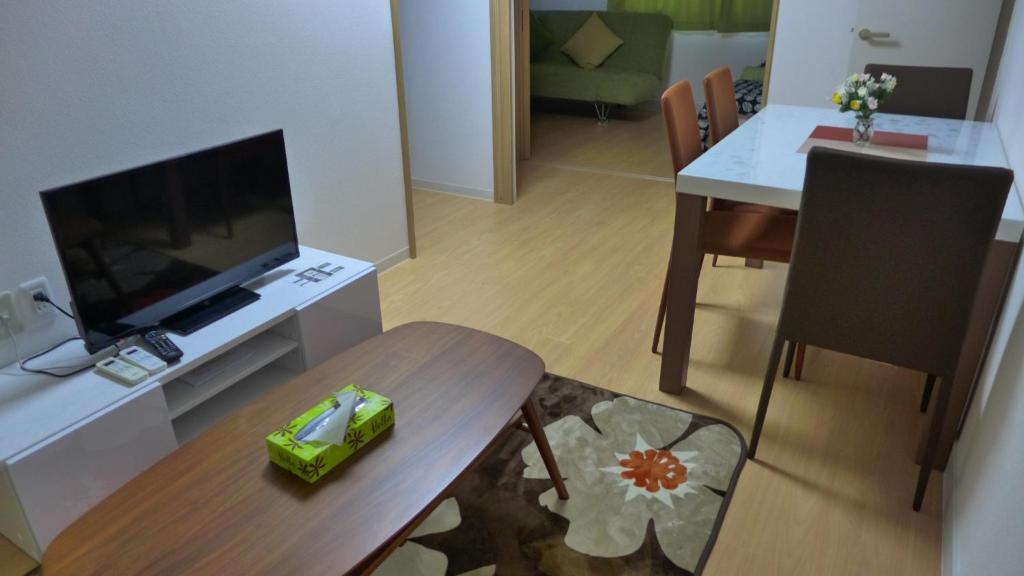 een woonkamer met een televisie en een eettafel bij Isshuku Ryokan Asakusabashi - Vacation STAY 17363v in Tokyo