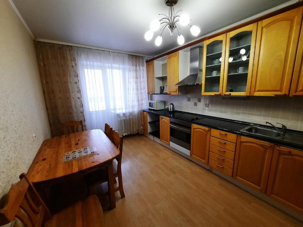ウファにあるApartment Mingazheva 140のウッドフロアのキッチン(木製テーブル付)