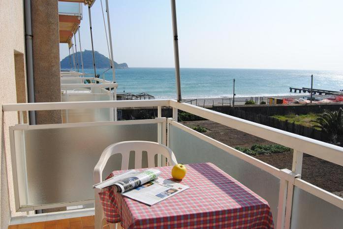 una mesa en un balcón con vistas al océano en Residence Riviera, en Albenga