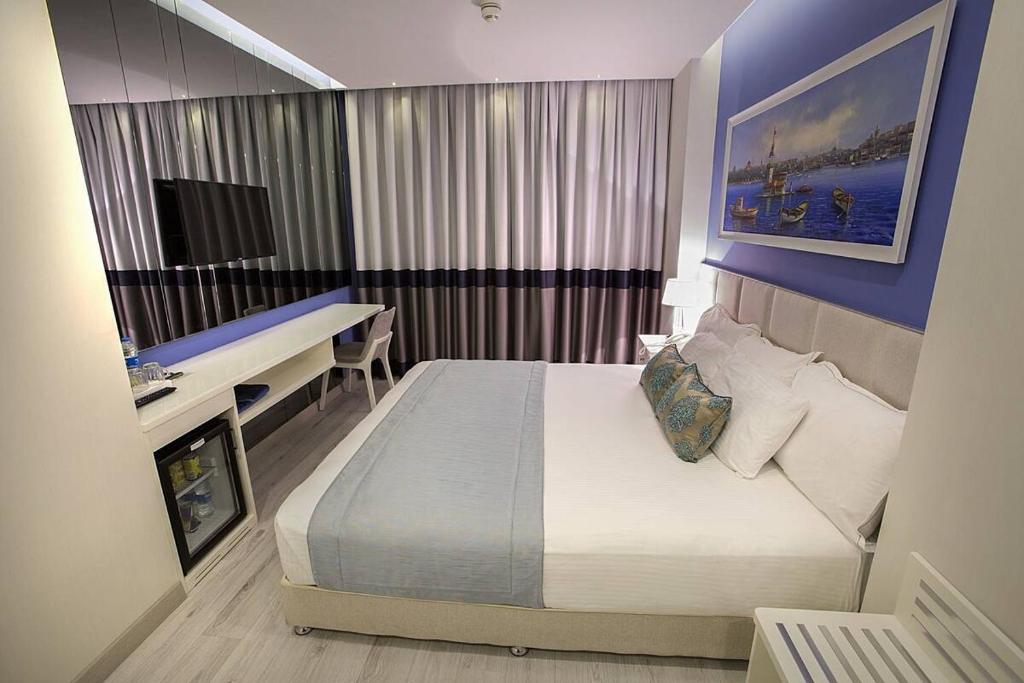 Habitación de hotel con cama, escritorio y ordenador en Ravvda Hotel en Estambul