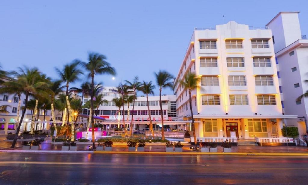 a building with palm trees in front of a street at Clevelander Hotel in Miami Beach