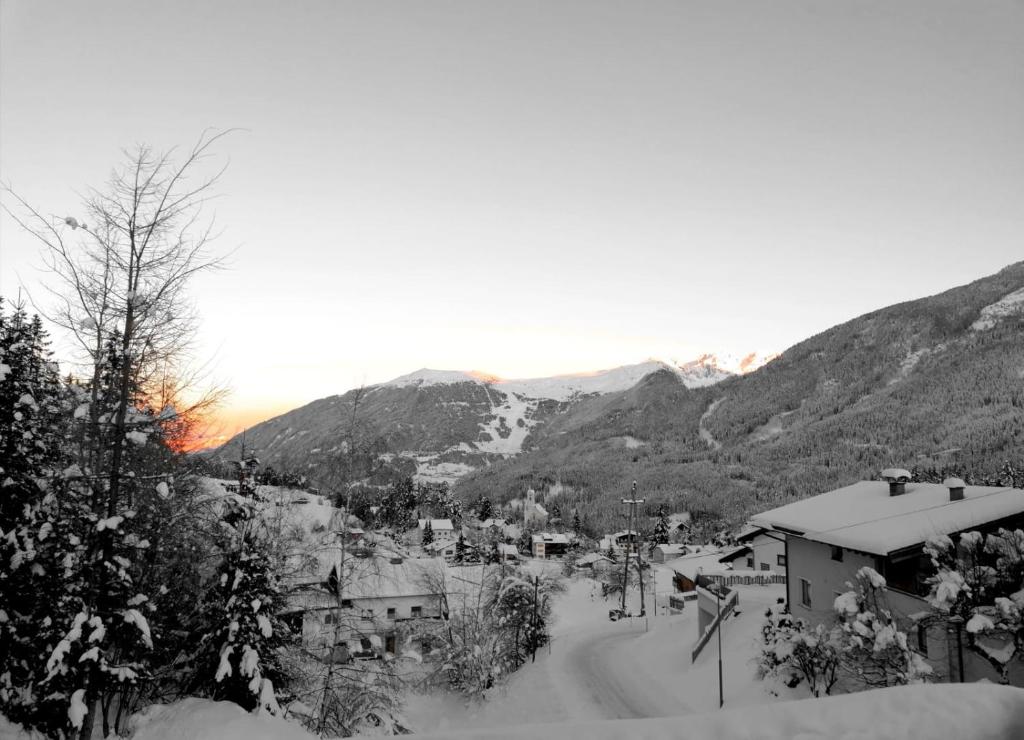 ein Dorf im Schnee mit Bergen im Hintergrund in der Unterkunft Bergperle Apartments & Mountain Sport in Fliess