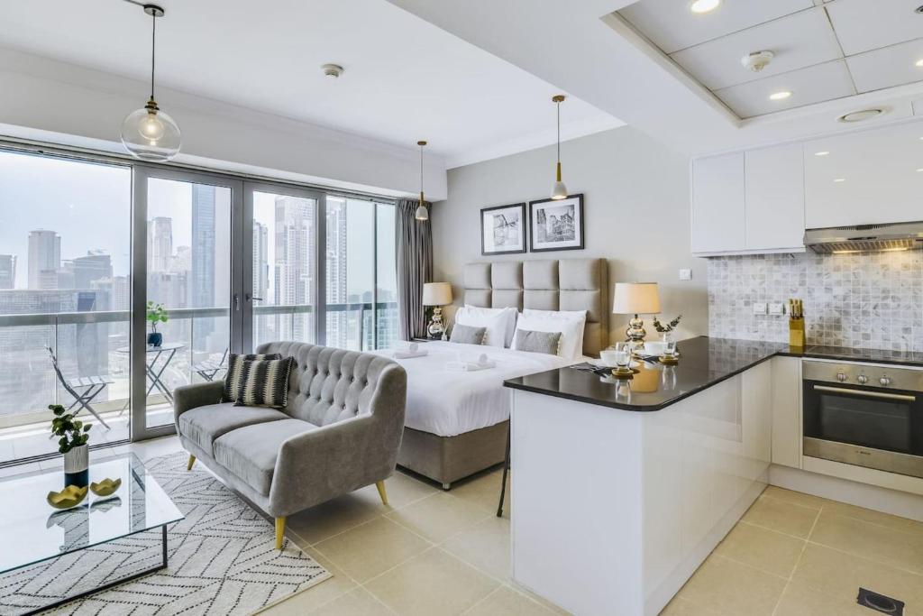 a kitchen and living room with a bed and a couch at GuestReady - Downtown Boulevard in Dubai