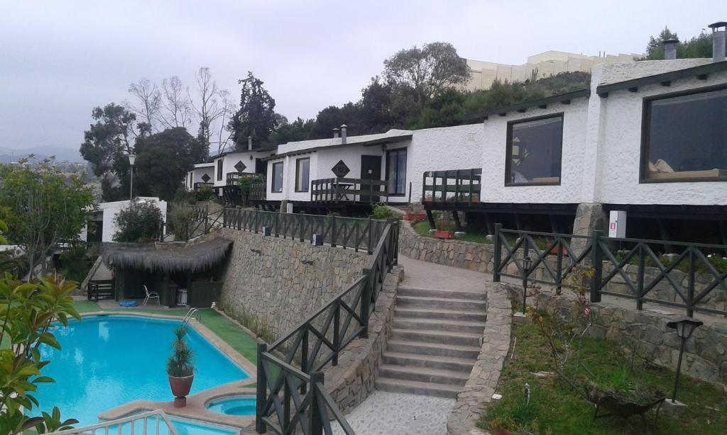 a house with a swimming pool next to a building at Mistral La Herradura in Coquimbo