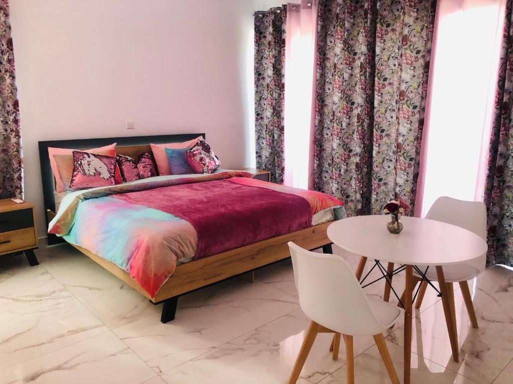 a bedroom with a bed and a table and chairs at Mobina Villas in Larnaka