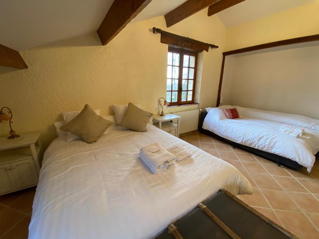 a bedroom with two beds and a window at Manoir du Suquet in Bardou