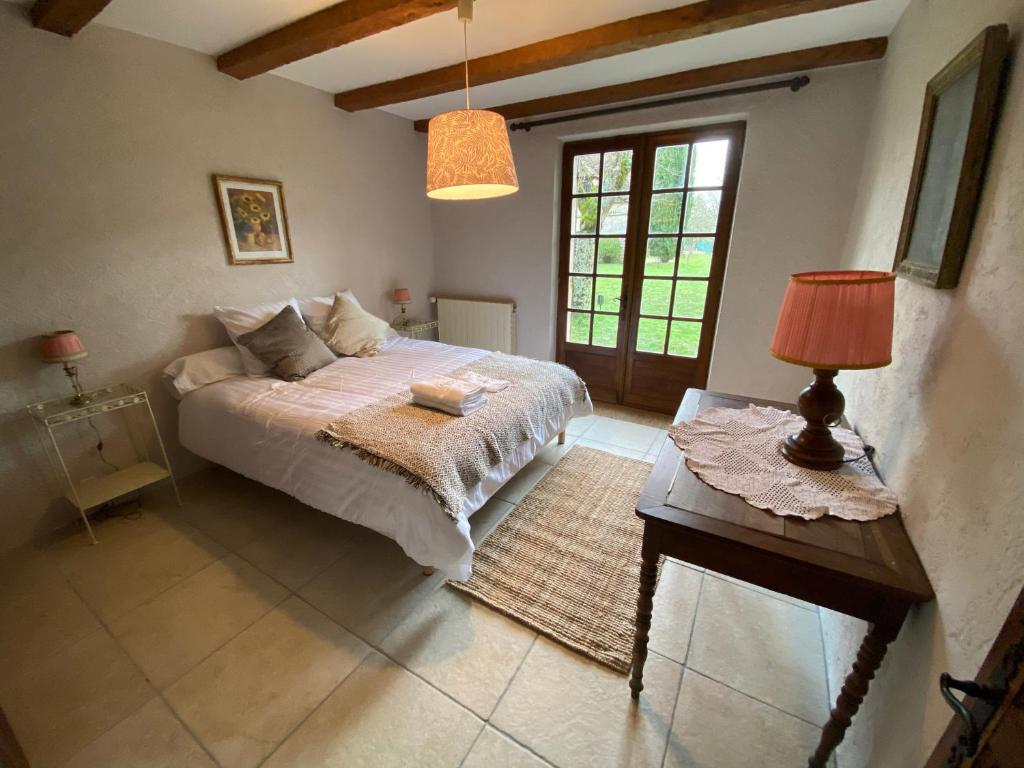 a bedroom with a bed and a table with a lamp at Manoir du Suquet in Bardou