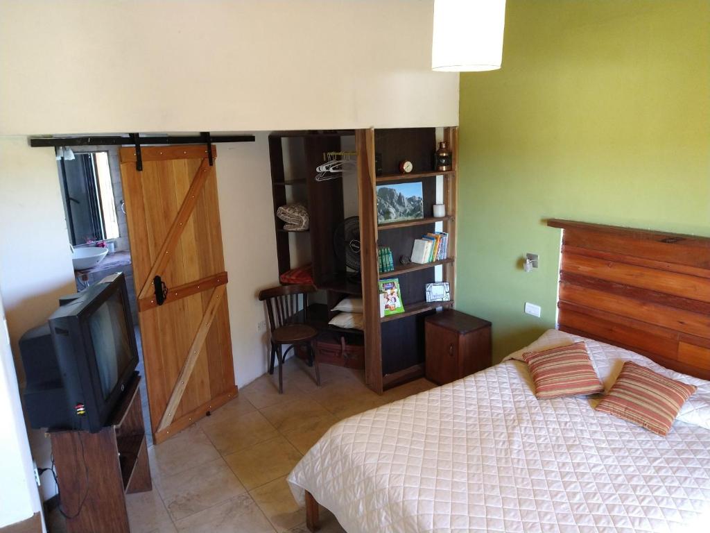 a bedroom with a bed and a tv and a door at Hermosa casa en Potrero de Garay in Potrero de Garay