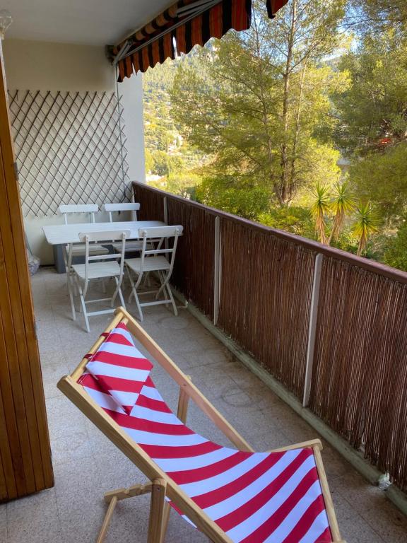 un fauteuil rouge et blanc sur un balcon dans l'établissement Appartement Le Panoramic - Terrasse et Parking, à Cassis