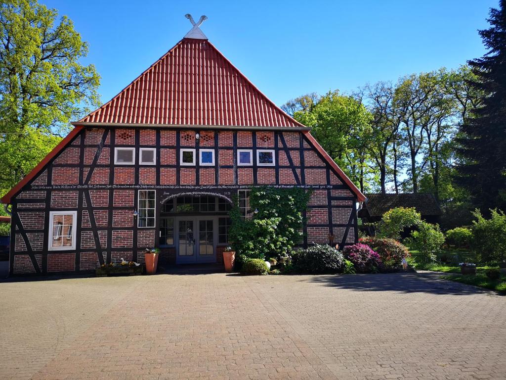 duży ceglany budynek z czerwonym dachem w obiekcie Ferienbauernhof Ennenhof w mieście Schneverdingen