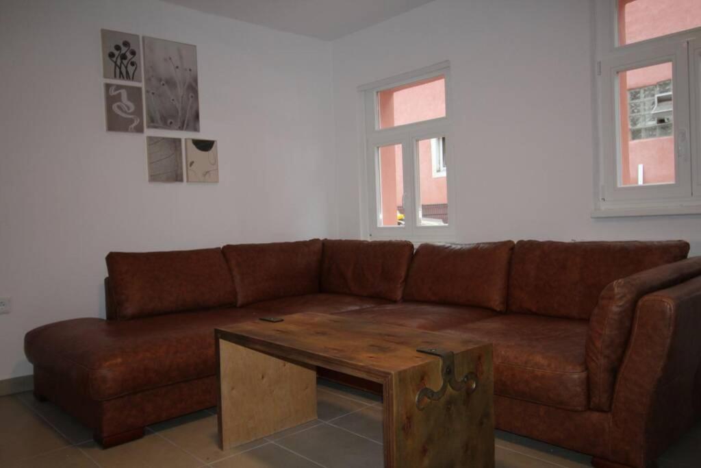 sala de estar con sofá marrón y mesa de centro de madera en Gonsenheim - 3-Zimmer-Haus - max. 5 Personen en Mainz