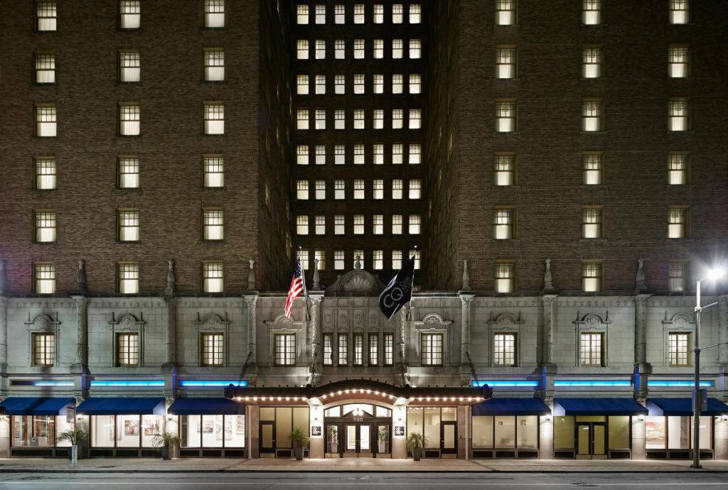 ein großes Gebäude mit einer Flagge davor in der Unterkunft Club Quarters Hotel Downton, Houston in Houston