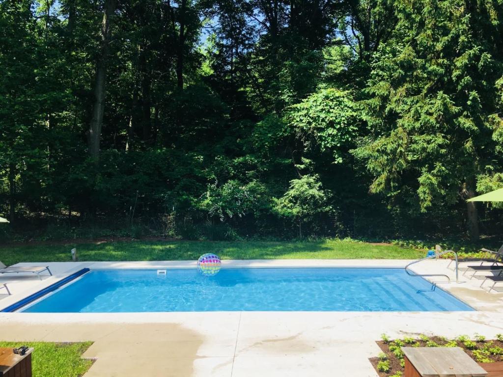 a small swimming pool in a yard with trees at Ravenswood Pool House in Sawyer