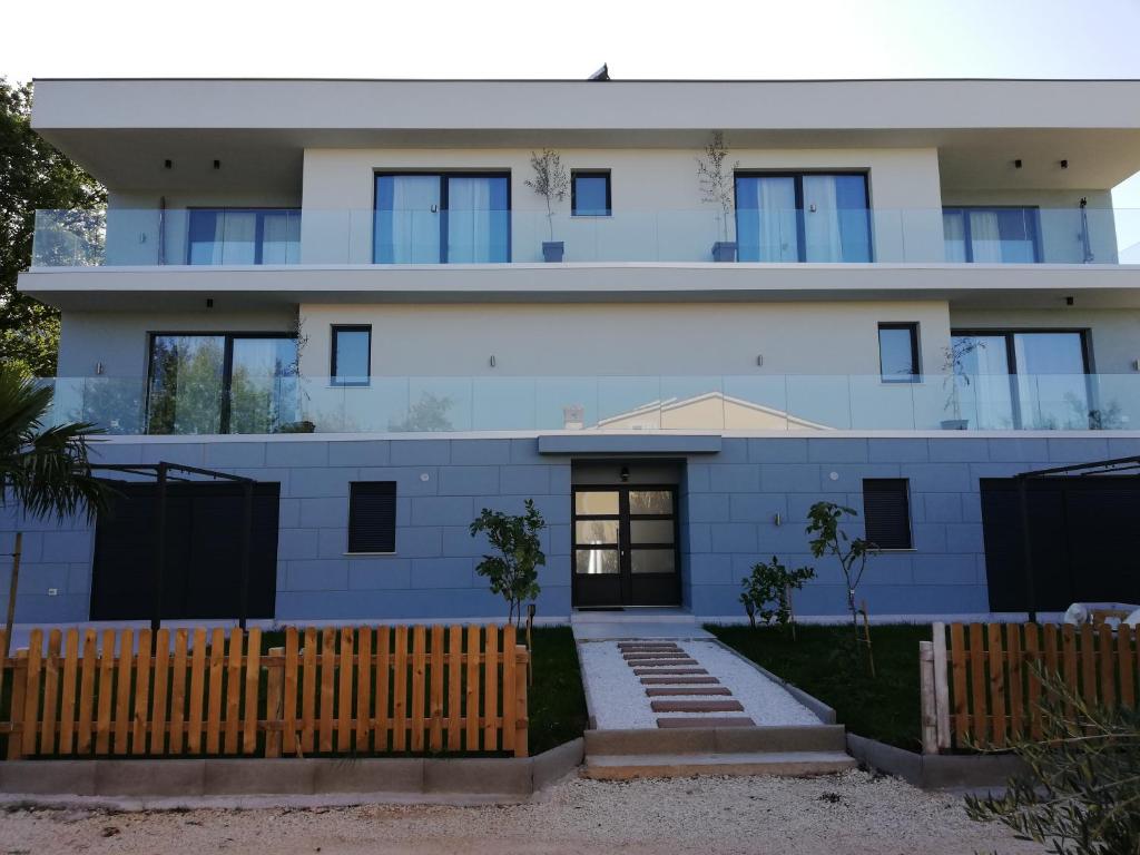 une maison blanche avec une clôture devant elle dans l'établissement Lovely 2-Bed Apartment in Drenje near Rabac, à Labin